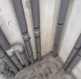 Exposed pipes running along a basement ceiling