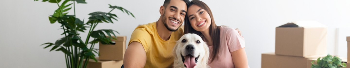 Couple smiling with their dog in a new home