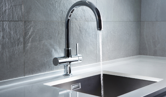 Black kitchen faucet running into a sink