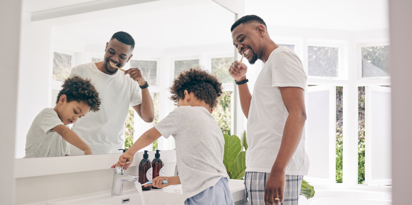 Family brushing their teeth together at a bathroom sink