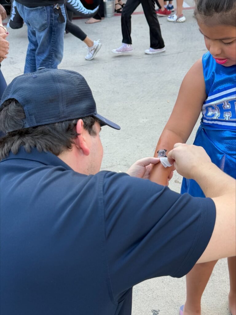 Friendly plumber giving promotional sticker to young child during Austin community event