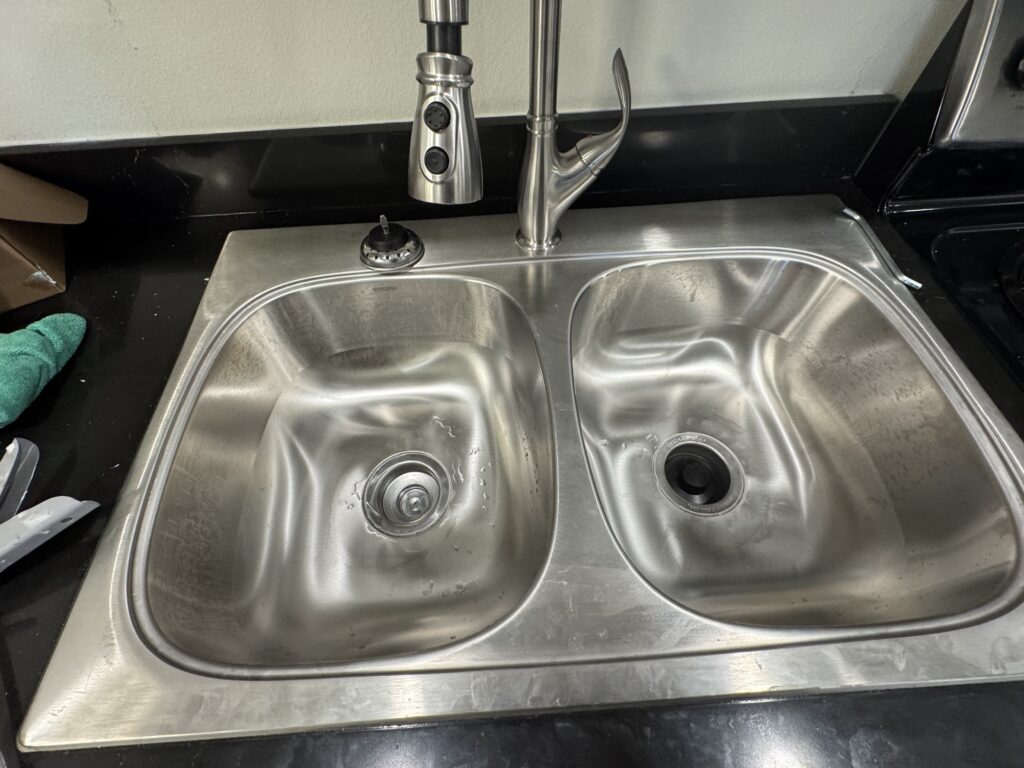 Stainless steel double kitchen sink with a pull-down faucet