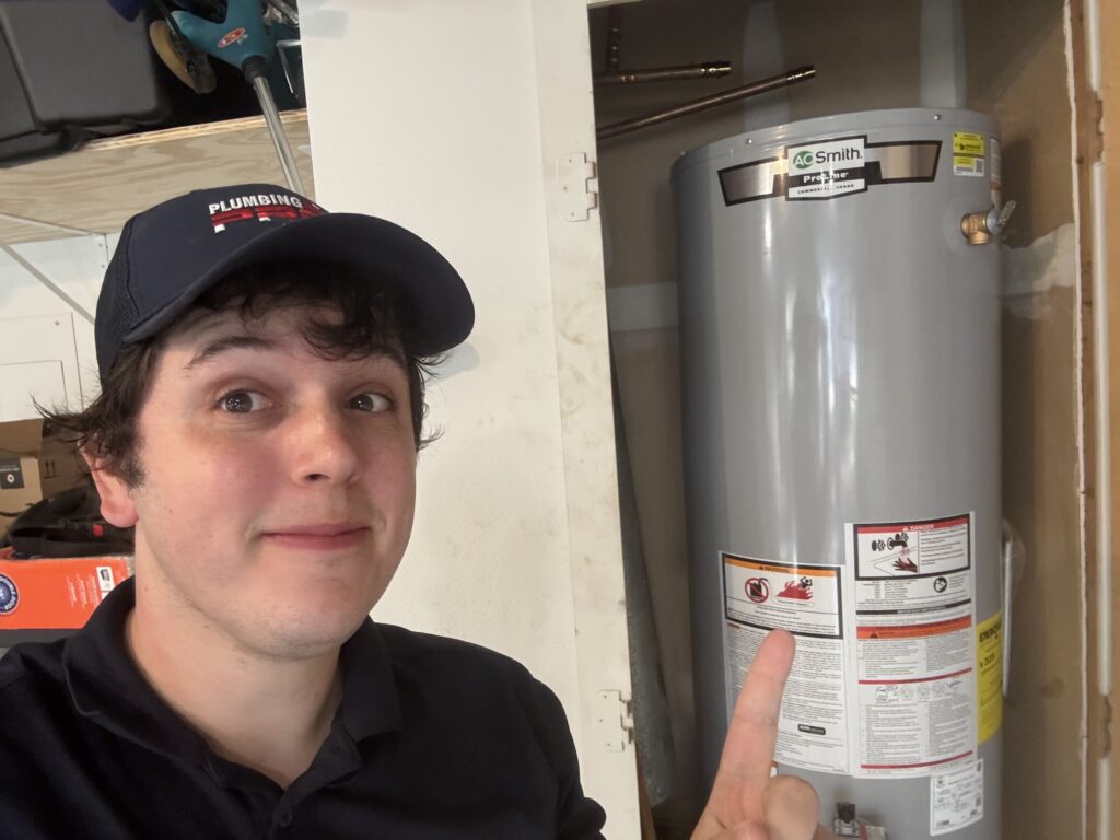 PlumbingPro technician pointing to a newly installed water heater
