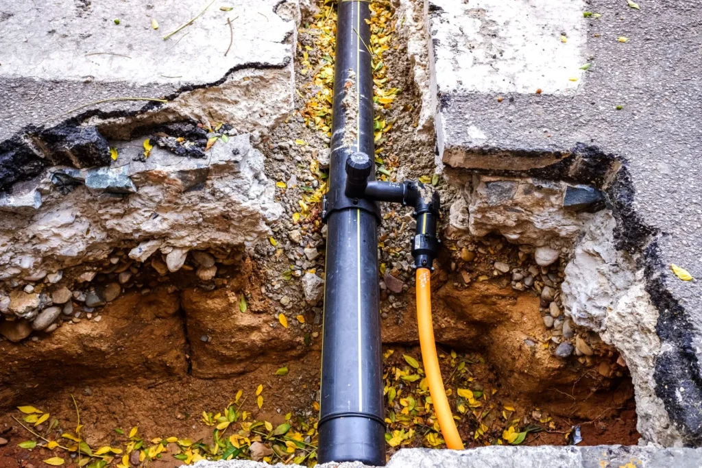 Water service line exposed in an excavated trench