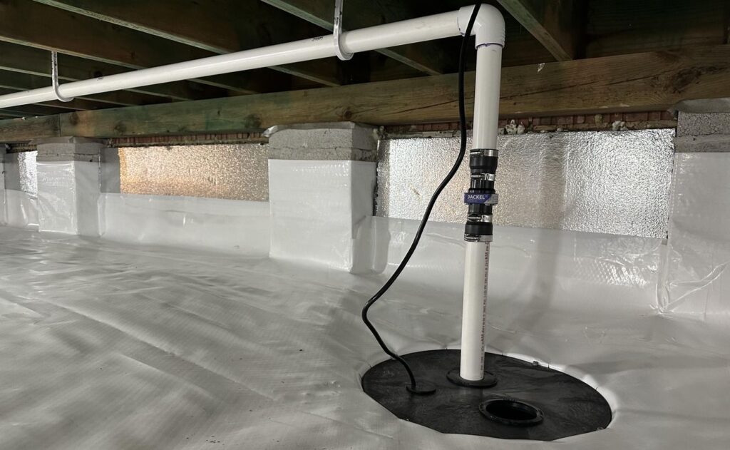 Sump pump installed in a crawl space with a white vapor barrier