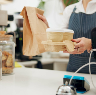 Café worker handing over a takeout order