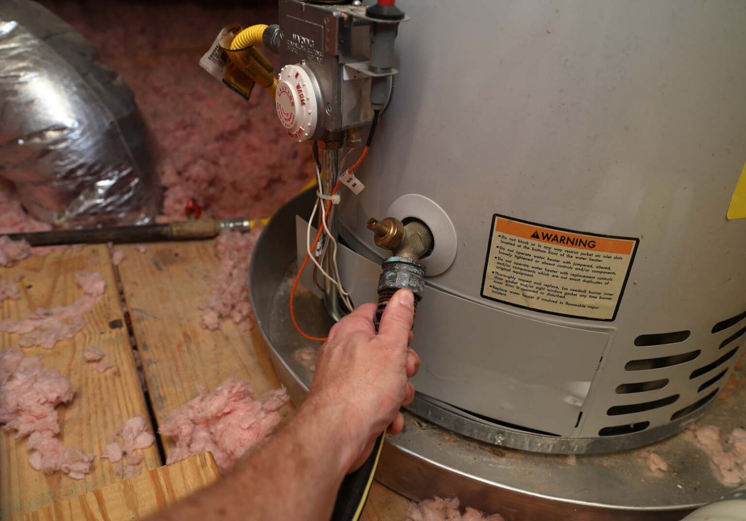 Hose connected to the drain valve of a gas water heater to flush the tank