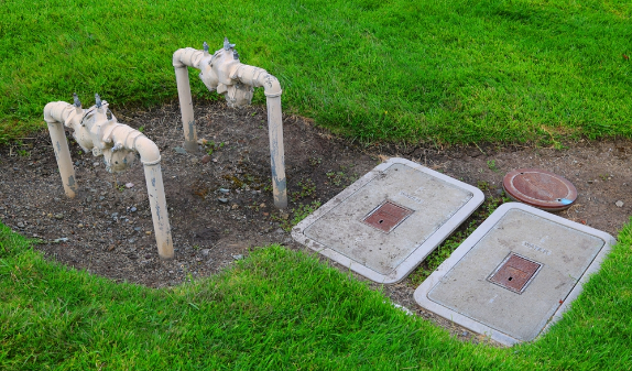 Backflow preventer valves and box covers on a lawn