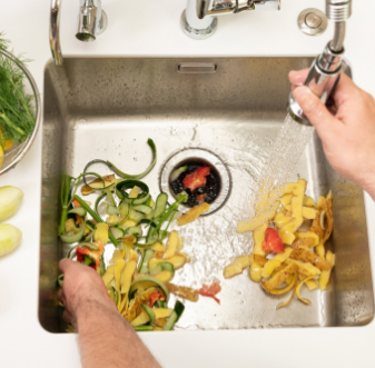 Food scraps in a kitchen sink with a garbage disposal