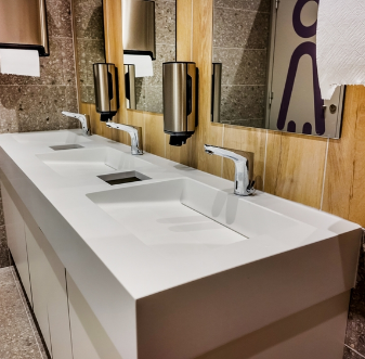 Commercial restroom with a long stone sink counter