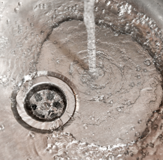 Water flowing into a stainless sink drain