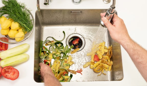 Food scraps in a kitchen sink with a garbage disposal