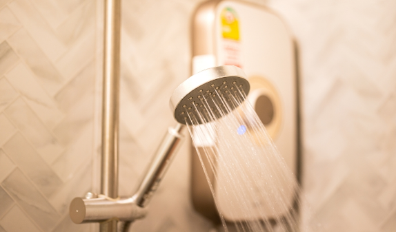 Shower head spraying water in a tiled bathroom