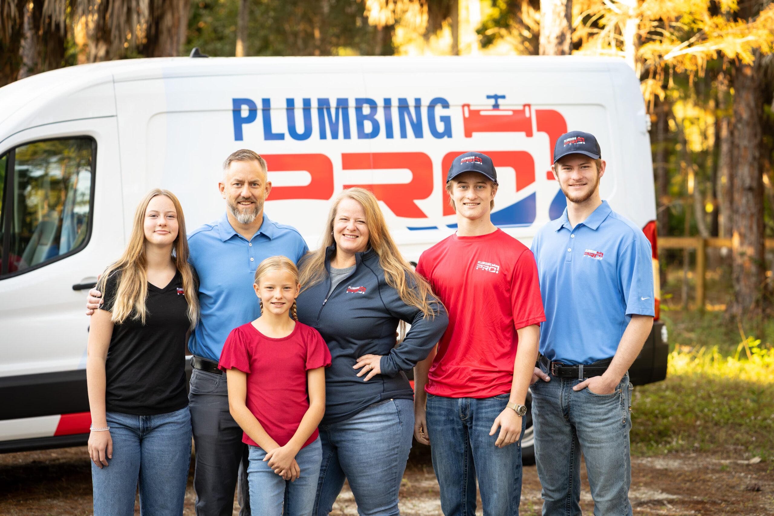 PlumbingPro team and a family standing in front of a PlumbingPro van