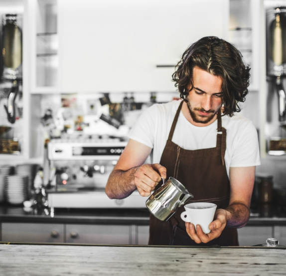 Barista pouring coffee at an espresso machine