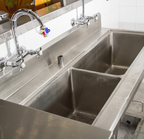 Stainless steel commercial sink with two faucets