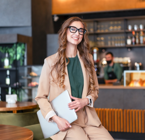 Smiling businesswoman with a laptop in a café