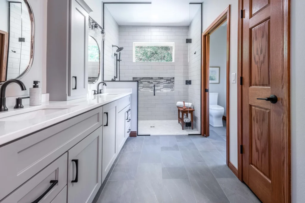 Remodeled bathroom with a gray vanity and walk-in shower