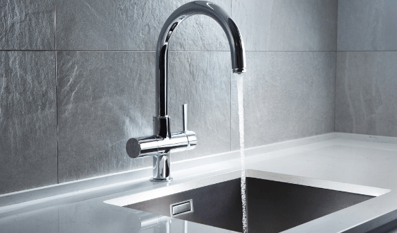 Black kitchen faucet running into a sink