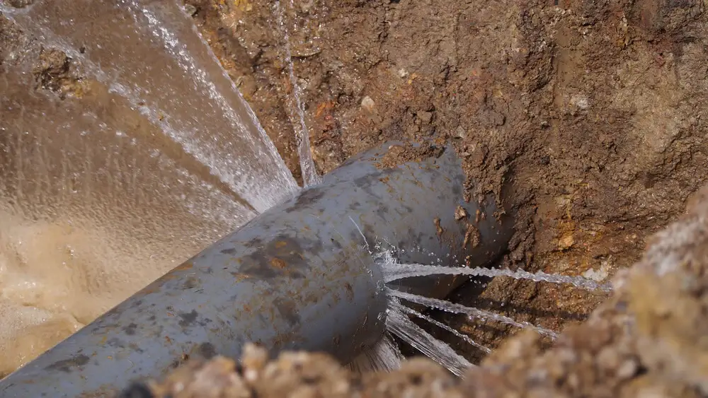 Water spraying from a leaking underground pipe