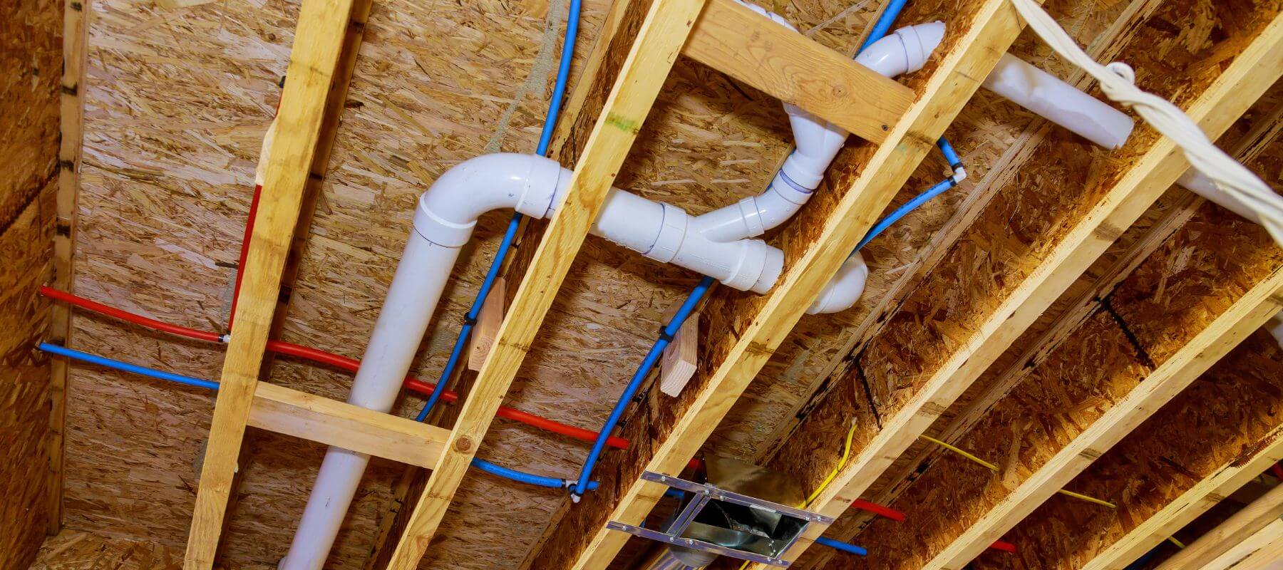 New white PVC drain pipes in open ceiling framing