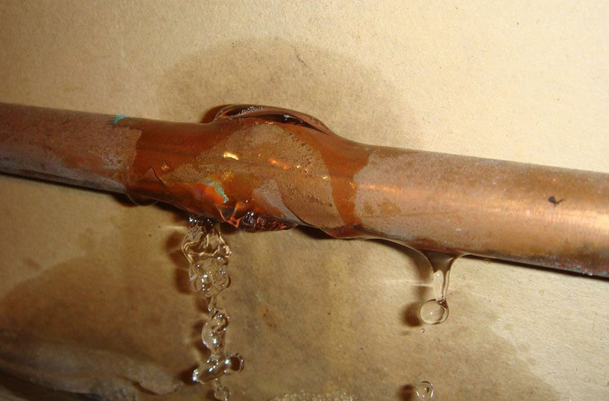 Water leaking from a corroded copper pipe joint