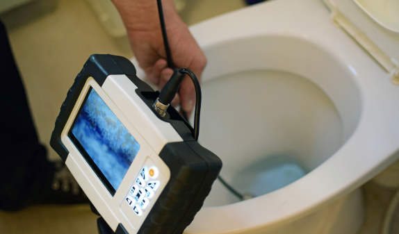 Camera inspection screen held over a toilet bowl