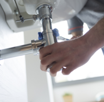 Plumber fixing a pipe under a bathroom sink