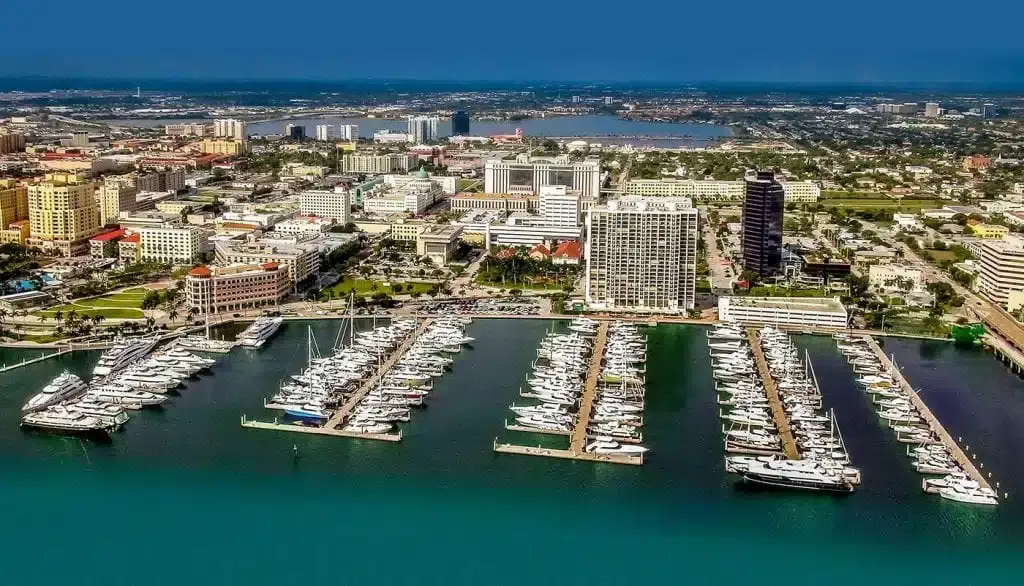 Aerial view of a marina full of boats beside a waterfront town