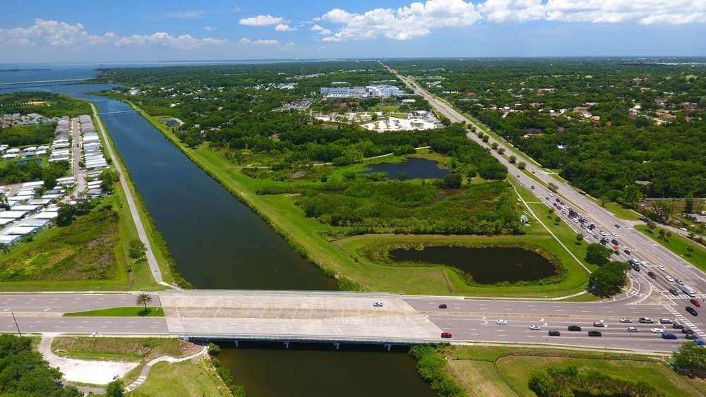 Aerial view of a canal, roads and green fields