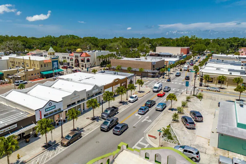 Aerial view of a downtown street with shops and parked cars