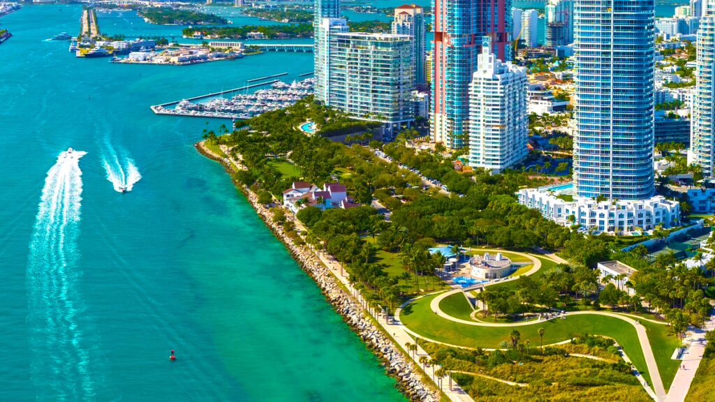 Aerial view of high-rise towers, a marina and turquoise water on the Florida coast