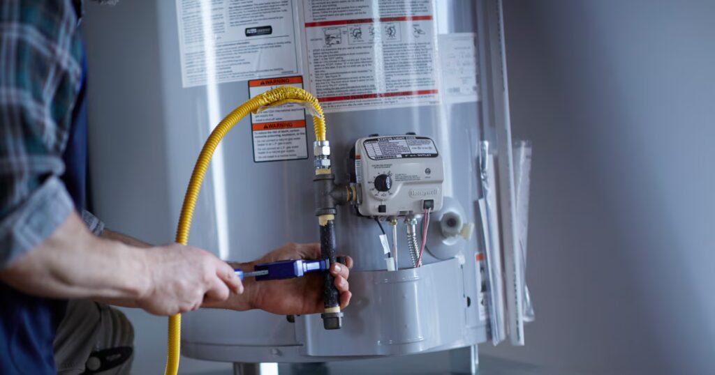 Technician adjusting the gas valve on a water heater