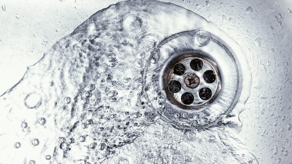 Water flowing down a stainless steel sink drain