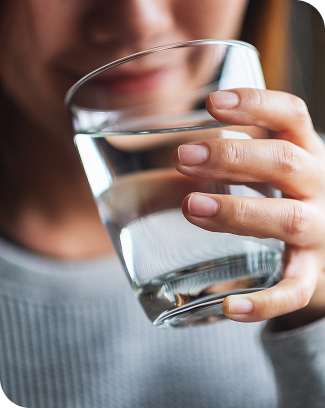 Woman holding a glass of clear drinking water