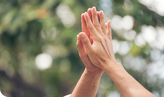 Two hands meeting in a high five outdoors