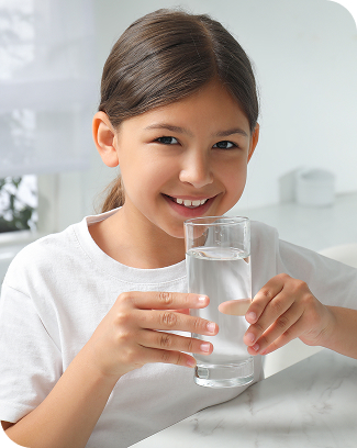 Smiling girl holding a glass of water