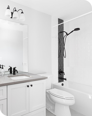 Clean white bathroom with vanity, toilet and shower tub