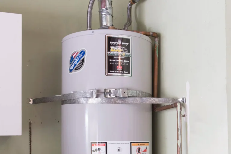 Tank water heater strapped to the wall with venting pipes