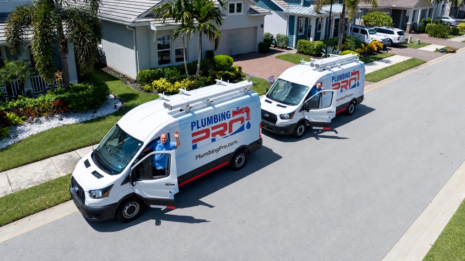 Aerial view of two PlumbingPro service vans parked on a residential street
